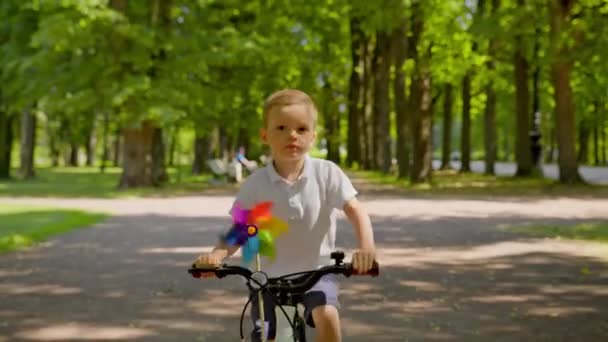 Portrait Happy Child Riding Bike Park Colorful Windmill Toy Blond — Stockvideo