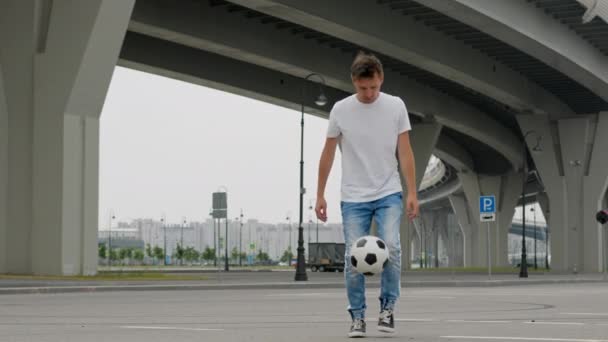 Young Man Wearing White Shirt Blue Jeans Juggles Ball Trestle — Vídeo de stock