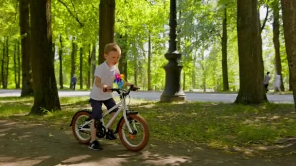 Happy Blonde Smiling Child Having Fun Riding Park White Bicycle — стоковое видео