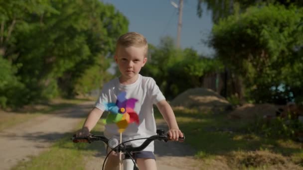 Smiling Blond Junior Schoolboy Rides Path Rider White Shirt Cycles — Stockvideo