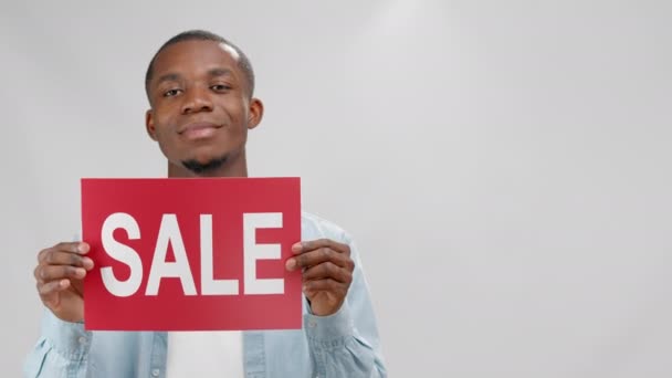 Smiling African American Young Man Demonstrates Informational Red Plate Inscription — Αρχείο Βίντεο