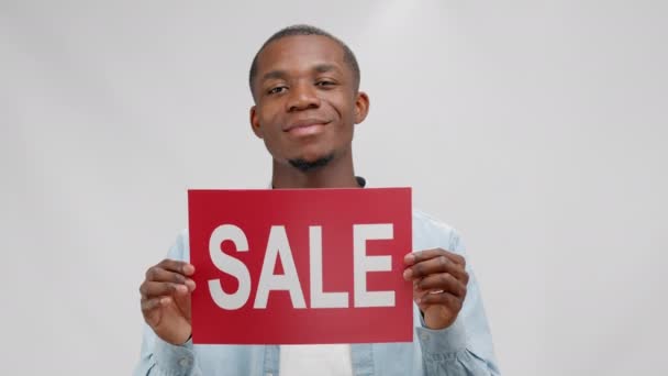 Smiling African American Young Man Demonstrates Informational Red Plate Inscription — 비디오