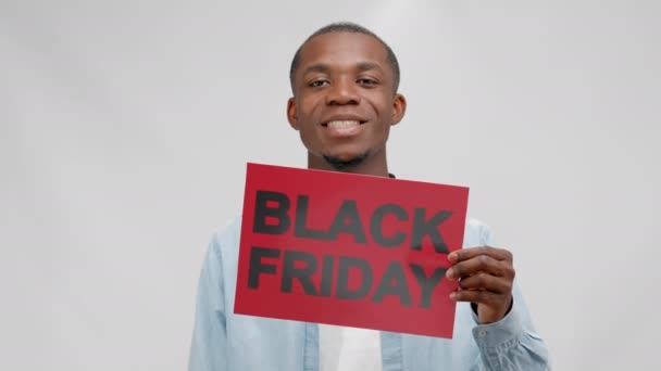 Cheerful African American Young Man Advertises Informational Red Plate Black — Vídeo de stock