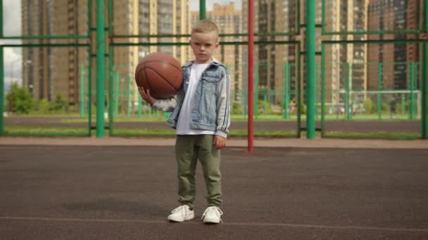 Concentrated Junior Schoolboy Holds Basketball Hand Fashionable Blond Child Modern — Video Stock