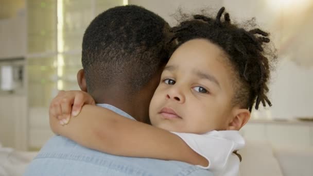 Child Looks Camera Hugging His Father Sitting His Arms Home — Wideo stockowe