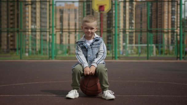 Smiling Preschooler Sits Basketball Blond Boy Fashionable Denim Jacket Green — Stockvideo