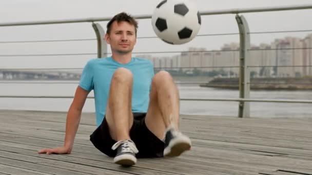Young Freestyler Juggles Ball Sitting Wooden Boardwalk Sportsman Demonstrates Juggling — Video Stock