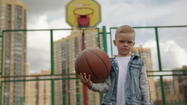 Fair Haired Child Holds Basketball Hand Sports Ground High Rise — Vídeos de Stock