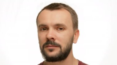 Side profile of adult dark-haired man. Middle-aged man with well-groomed beard and mustache turns head and smiles. Man has facial wrinkles and receding hairlines