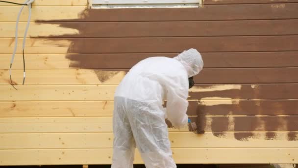 Man Professional Painter Protective Suit Painting Wooden Facade House Wall — Vídeos de Stock