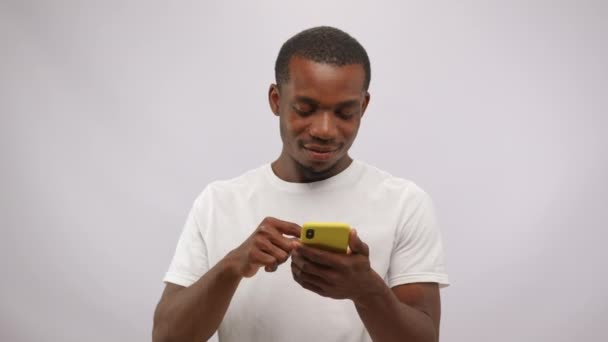 Young Man Scrolls Smartphone Smiles Seeing Results Open Audition African — Vídeo de Stock