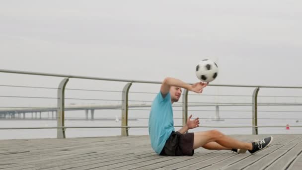 Man Soccer Player Performing Amazing Tricks Spinning Football Ball Sitting — Αρχείο Βίντεο