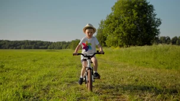 Little Child Boy Hat Riding Bike Windmill Green Field Country — Stockvideo