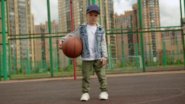 Kid Boy Denim Shirt Standing Basketball Court Holding Ball Hands — Stockvideo