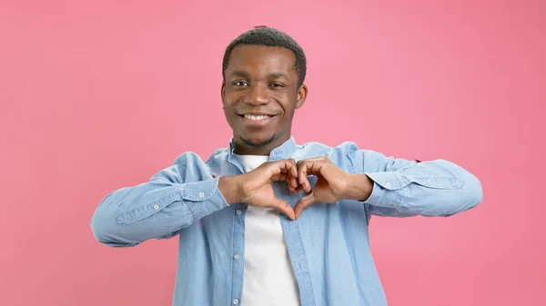 Portrait happy young Afro american man volunteer showing hands sign heart shape looking at camera. Healthy heart health life insurance, love and charity, voluntary social work, organ donation concept