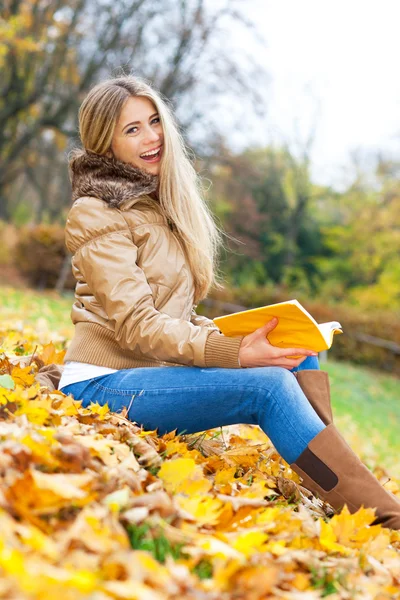 Frau lacht beim Lesen im Park — Stockfoto