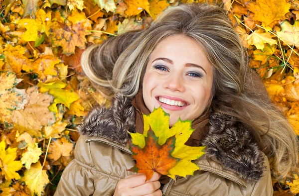 Smile in autumn leaves — Stock Photo, Image