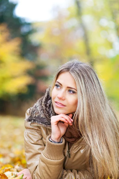 Nice woman in a park in autumn — Stock Photo, Image