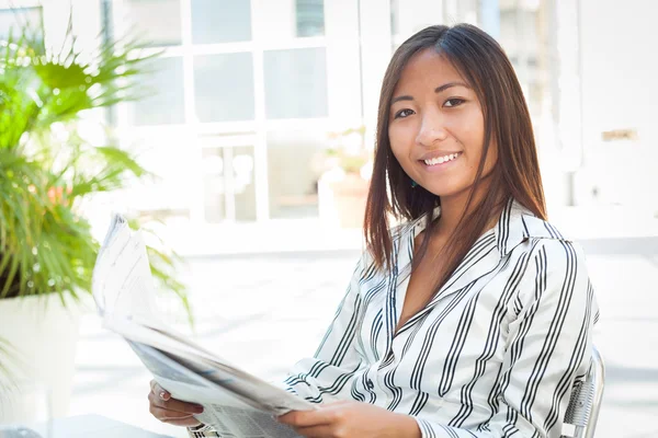 Junge asiatische Frau liest Zeitung — Stockfoto