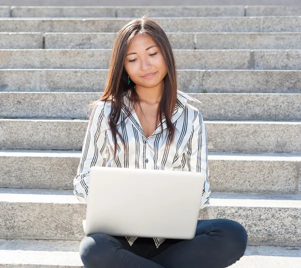 Cute asian girl using a laptop outdoor — Stock Photo, Image