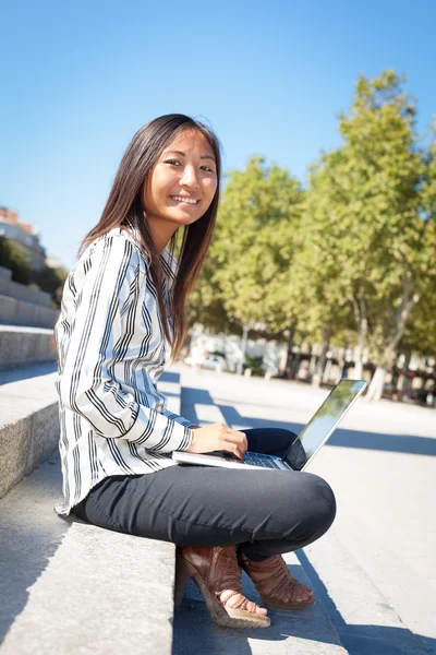 性格开朗的年轻亚洲女孩在笔记本电脑上工作 — 图库照片