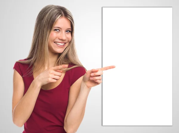 Uśmiechnięta kobieta pokazano puste afisz — Zdjęcie stockowe