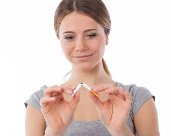Mulher quebrando um cigarro (foco no cigarro ) — Fotografia de Stock