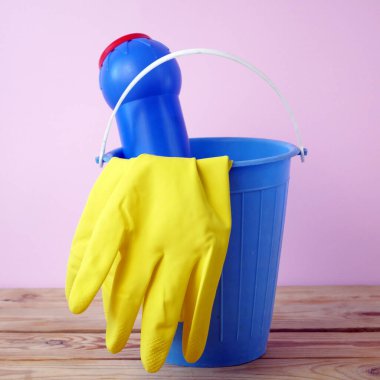 Mutfakta fırça, eldiven ve deterjan dolu plastik kova, temizlik malzemeleriyle dolu sepet, yakın çekim.