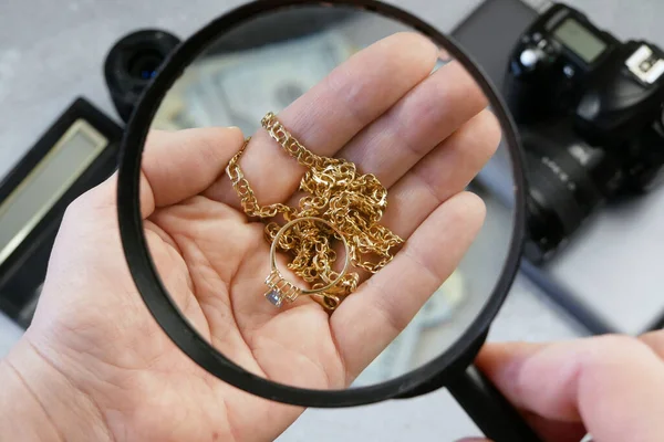 Pawn shop worker verify jewellery and photo or video camera and give money. Customers Buy and Sell Precious Metals, Jewels, Ancient Coins and Second Hand Electric Appliances. Closeup