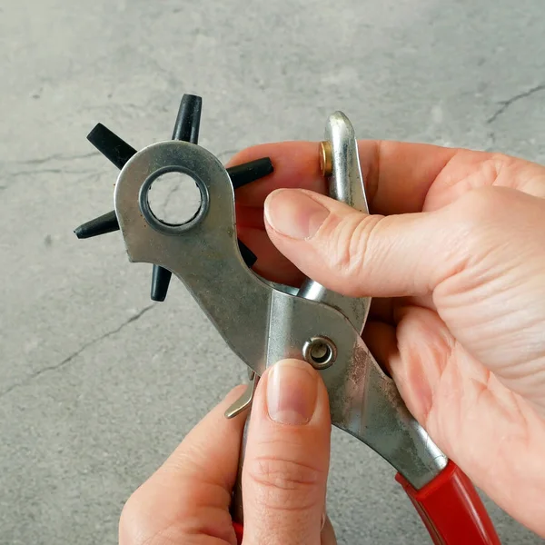 Bronzlaştırıcı ile deri kemer üretme süreci. Yumruk atarak kayış deliklerini deldim. Kemerli Delik Yumruklayıcı Güç Desteği Ağır Görevli Dönen Gözlü Yumruk Kerpeteni. Yakın çekim.