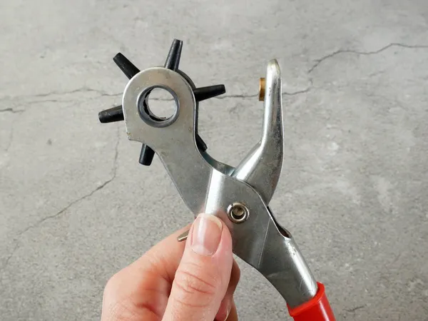 Bronzlaştırıcı ile deri kemer üretme süreci. Yumruk atarak kayış deliklerini deldim. Kemerli Delik Yumruklayıcı Güç Desteği Ağır Görevli Dönen Gözlü Yumruk Kerpeteni. Yakın çekim.