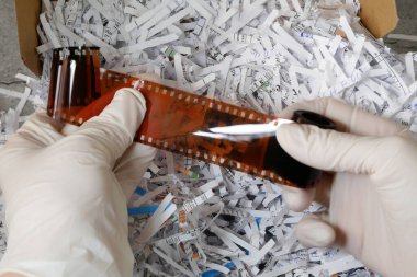 Kağıt öğütücü kağıtları arasında kamera için çok gizli antika film bilgileri ve beyaz eldivenler, hırsız bilgi konsepti, yakın çekim