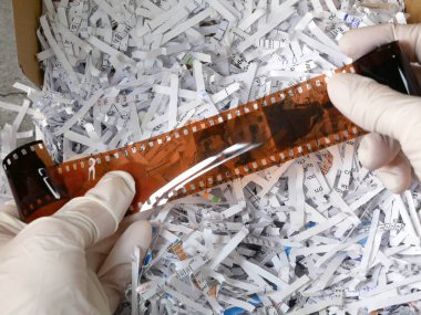 Kağıt öğütücü kağıtları arasında kamera için çok gizli antika film bilgileri ve beyaz eldivenler, hırsız bilgi konsepti, yakın çekim