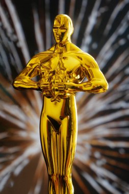 Havai fişek arka planında altın adam heykeli, yakın plan
