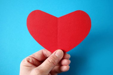 Kırmızı kalbi tutan el. Organ bağışı, aile sigorta konsepti. Dünya Kalp Günü, Dünya Sağlık Günü. Aşk ve Sevgililer Günü 'nün sevgili kavramı. Üst görünüm