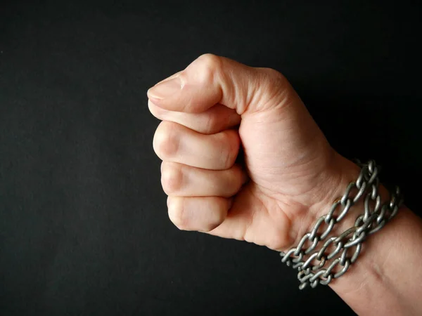 黒い背景に鎖の形で手錠で拳に手を握りしめ奴隷と暴力の概念の問題 青年期の自由破壊チェーン — ストック写真