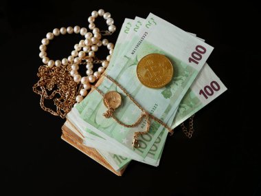 çok sayıda altın ve gümüş mücevher, bitcoin ve nakit para siyah fırın, rehinci konsepti, kuyumcu konsepti, yakın çekim