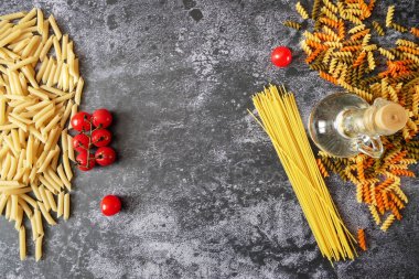 Çeşitli makarna türleri (fusilli, penne, cavatapi, cannelloni, spagetti) siyah arka plan, çiğ makarna seti ve domates, set, koleksiyon, kapanış