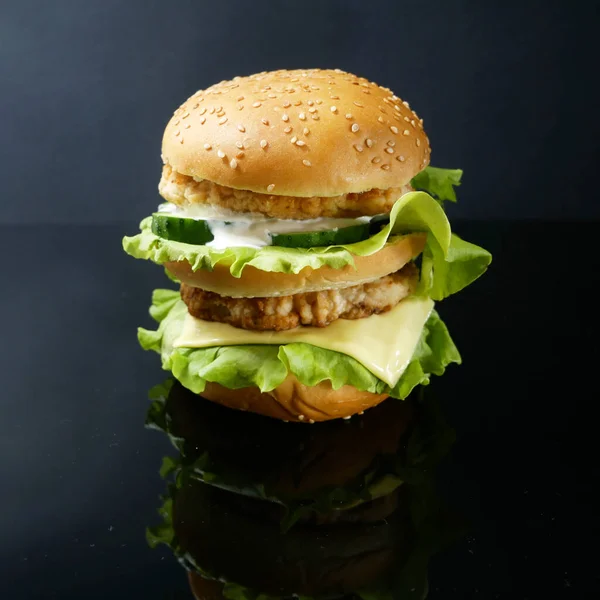 Duży Burger Mięsem Sałatą Serem Ogórkiem Pomidorem Czarnym Tle Zbliżenie — Zdjęcie stockowe