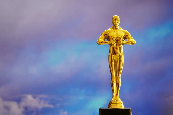 golden man statue on fireworks background, closeup