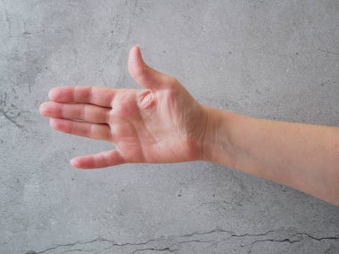 Gri arka planda, avuç içi bir şeyi işaret ediyor. Yakın çekim