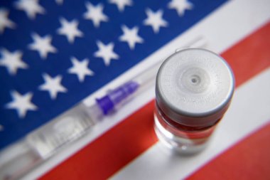 Amerikan bayrağı, Coronavirus aşısı ve parası olan şırıngalar, satın alma ve üretim aşısı için para, yakın çekim 