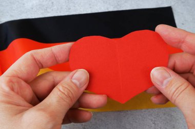 Almanya 'yı seviyorum. Almanya bayraklı arka planda kırmızı kalp sembolü. Alman Birliği Günü - 3 Ekim, yakın plan