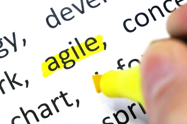 Word agile undelnines among other words printed on white paper. projects methodology and development team workflow concept. Closeup