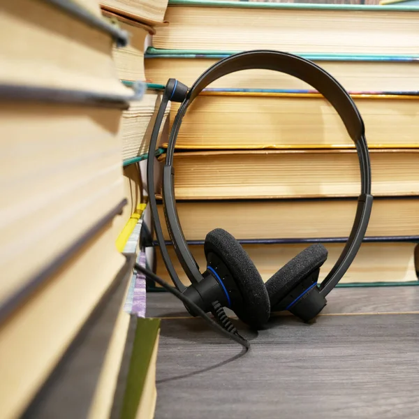 木製の背景にヘッドフォンや本 オーディオブックのコンセプト オンライン図書館アーカイブ — ストック写真
