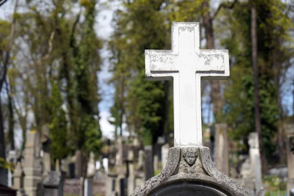 Geleneksel Avrupa mezarlığında mezar. Yıllanmış haç mezar taşı üzerinde mezar taşı. Açık havada.