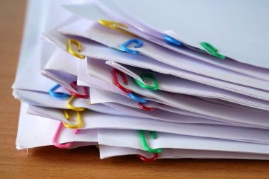 El, cilt klipsli doküman yığınını alır tahta masa, yakın plan