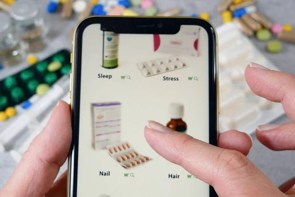 hand scrolling through the site in medicines, buying medicines online on pills and stethoscope background,The concept of online pharmacy, closeup