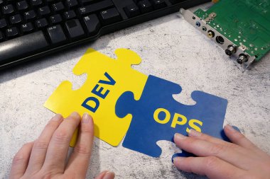 Dev ve Operasyon sembolü anakart ve klavye arka planında. Yazılım mühendisliği kültürü ve yazılım geliştirme ve işletim uygulaması için DevOps kavramı, yakın plan