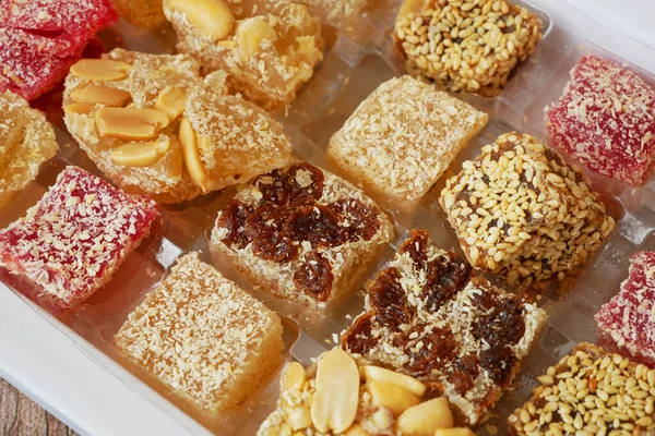 Eastern sweets with nuts, candy, dates in box background, closeup